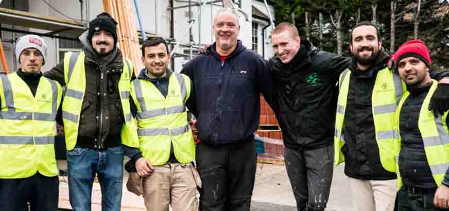 A team of builders posing for a group photo on site